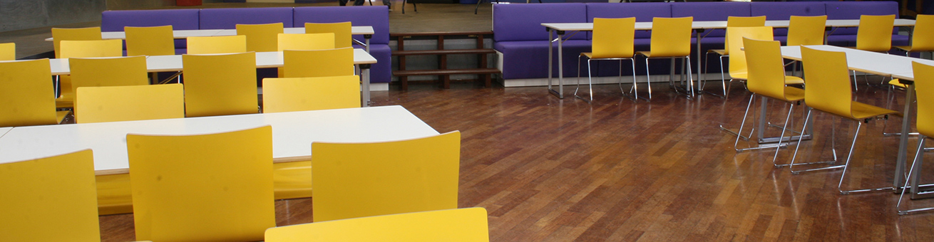 De aula ingericht met Buggy Fold (klaptafel), MC Sofa banken en gele X-Ray stoelen.